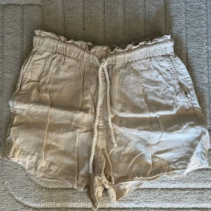 Beige shorts från H&M - Linne shorts från H&M Strl S Dam 📷 Säg till om du vill ha fler bilder så fixar jag det.  💸 Vid snabb affär kan ja tänka mig att sänka priset. ✉️ Köparen står för frakten.  📍 Kan mötas upp i Tyresö.