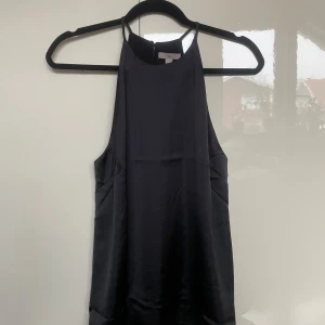 Svart satin topp - Snygg svart halterneck topp i satin. Aldrig använd men prislappen är dock inte kvar🥰