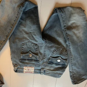 Blå jeans med fickdetaljer - Utsvängda bootcutjeans från true religon jag har använt endast 1 gång