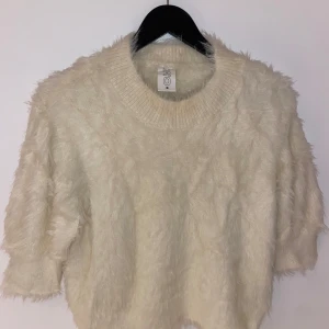 Vit fluffig tröja från C.W. - Mysig och fluffig vit tröja från C.W. Perfekt för kyliga dagar med sin mjuka och bekväma design. Tröjan har en rund hals och trekvartsärmar, vilket ger en avslappnad look!💕
