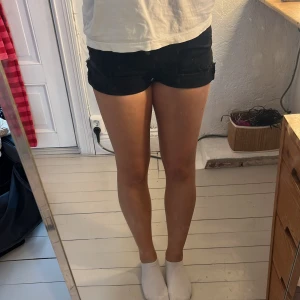 Svarta högmidjade jeansshorts med fransar - Snygga svarta jeansshorts med fransiga kanter och knappar framtill. De har en klassisk femficksdesign och är högmidjade för en bekväm passform. På de två första bilderna har jag vikt upp dom, dom två efter ser man hur dom ser ut nedvikta💕