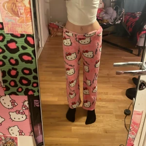 Rosa Hello Kitty mjukisbyxor - Supermysiga rosa mjukisbyxor med Hello Kitty-motiv. Byxorna har en loose passform och är perfekta för en avslappnad dag hemma. De är tillverkade i ett mjukt material som känns skönt mot huden.💓