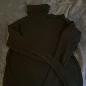 Svart långärmad tröja - Säljer en stilren svart tröja i liten storlek. Perfekt för kyligare dagar med sin höga krage och långa ärmar. En klassisk baströja som passar till det mesta.