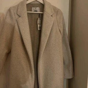 Beige kappa från Zara - Säljer en stilren beige kappa från Zara i storlek XS. Perfekt för höst och vår. Aldrig använd, kom provat för fler bilder!🫶🏼💕
