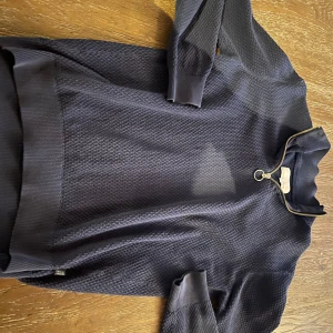 Mörkblå tröja med dragkedja från Casual Friday - Säljer en stilren mörkblå tröja från Casual Friday. Tröjan har en dragkedja vid halsen och ett diskret mönster som ger en snygg textur. Perfekt för kyligare dagar.