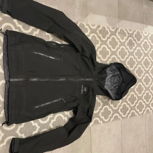 Svart regnjacka från Arc'teryx - Säljer min svarta gore text skal jacka från Arc'teryx, super fin jacka som går att använda året om. Är använd i 1,5 år men i superfint skick!
