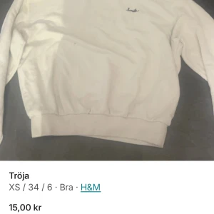Vit tröja från H&M - Vit tröja från H&M i storlek XS. Tröjan har långa ärmar och en enkel design med en liten broderad detalj på bröstet. Perfekt för en avslappnad stil.