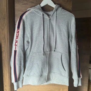 Gucci hoodie  - Snygg grå hoodie från Gucci med dragkedja och luva. Använd ett tag, men inga defekter, utmärkt skick. Pris går att diskutera. Det är size XS men sitter som en S. 