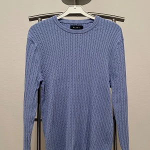 Ljusblå stickad tröja från brothers - En kabelstickad tröja från brothers egna märke Riley. Tröjan är ljus blå färg och har en normal passform (storlek medium). Tröjan är i bra skick och är bara använd ett fåtal gånger. Den är köpt för 799 ordinarie pris. Vid frågor kontakta pm!