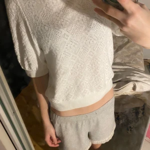 Vit kortärmad topp från Holly & Whyte - Säljer en stilren vit topp från Holly & Whyte by Lindex. Den har korta ärmar och en fin textur i tyget. Perfekt för en avslappnad look. Har aldrig andvänt tröjan, det är varför jag säljer tröjan.