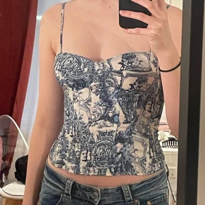 Mönstrad korsett från PrettyLittleThing - Snygg korsett från PrettyLittleThing med ett unikt blått och vitt mönster. Den har smala axelband och en figurnära passform som framhäver silhuetten. Perfekt för att ge en stilfull touch till din outfit. Säljer då den är  för stor för mig (bild 2). Jag brukar vara mittemellan xs/s så tror den skulle passa bättre på någon som är s/m.