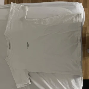 Vit t-shirt från Acne Studios - Snygg vit t-shirt från Acne Studios. Trycket är lite urtvättat, annars i bra skick. Passar xs-s. 