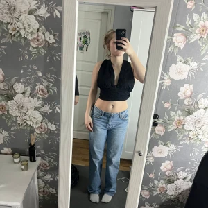 Svart omlott topp - Snygg svart omlott topp med knytning i ryggen. Toppen är ärmlös och har en djup v-ringning framtill. Perfekt för en stilren och trendig look.(igga min BH) väldigt snygg baktil 