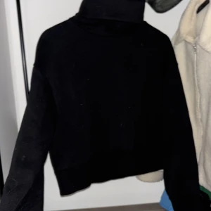 Svart croppad polotröja från Zara - Säljer en stilren svart croppad polotröja från Zara. Perfekt för en trendig look med hög krage och långa ärmar. Passar utmärkt till både jeans och kjol. 🖤