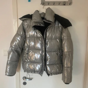 Silver pufferjacka från BikBok - Snygg och glansig silverfärgad pufferjacka från BikBok. Denna jacka säljs inte längre!