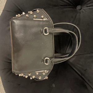 Zara väska med nitar - Säljer nu denna snygga väska från Zara med nitar på sidorna. Den är även i bra skick och bandet följer med.💕