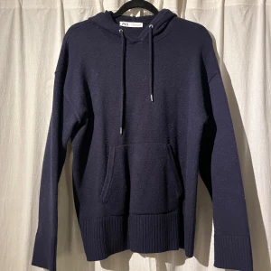 Mörkblå hoodie från Zara - Säljer en stilren mörkblå hoodie från Zara. Tröjan har en klassisk design med dragsko i huvan och en praktisk magficka. Perfekt för kyligare dagar.
