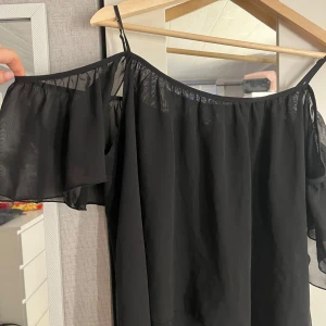 Svart offshoulder topp från Gina Tricot - Svart offshoulder topp från Gina Tricot i storlek 36. Går att bära både offshoulder och med ärmarna på (se bilder)