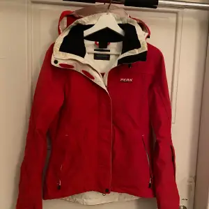 Riktigt schysst röd skidjacka från Peak Performance med dragkedja och huva. Jackan har långa ärmar och praktiska fickor med dragkedjor! Jackan har ett goretex membrane perfekt för skiddagar🤗