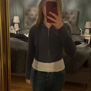 Mörkgrå hoodie från Gina Tricot - Säljer en mörkgrå/blå hoodie från Gina Tricot med dragkedja framtill. Den har långa ärmar och en bekväm passform.