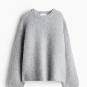Grå stickad tröja - Den populära och helt slutsålda stickade tröjan från H&M i mohairblanding! Säljer då den är för liten för mig tyvärr. Oanvänd med prislappen kvar! Orginalpriset  är 699kr och jag säljer för 450kr. Färgen är som på första bilden. 