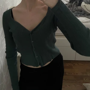 Topp - Snygg grön/turkos ribbad topp med hjärtformad urringning, långa ärmar, knappstängningar ner längs framsidan och en mjuk ribbdesign. I mycket bra skick!☺️