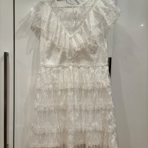 Vit spetsklänning från Bubbleroom - Vit klänning i spets från Bubbleroom med volangdetaljer. Säljer då jag hittat en annan studentklänning, nypris: 899 kr