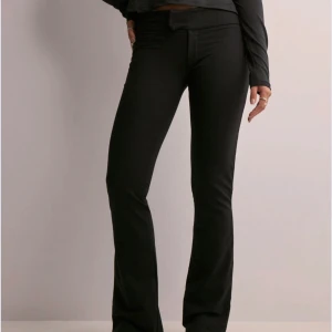 Kostymbyxor  - Snygga svarta kostymbyxor. Perfekta för en stilren look. Byxorna har en tight passform upptill och vidgar sig vid anklarna.