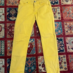 Gula byxor från Tramarossa - Snygga gula byxor från Tramarossa med normal passform. Byxorna har en klassisk design med knappar och dragkedja framtill. Perfekta för att liva upp garderoben med en färgklick.