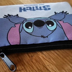 Söt liten förvaring med Stitch-motiv! - Söt liten förvaring med dragkedja för småsaker t ex kontanter, smink eller mediciner. Mått: 15 x 11 cm. Ny!
