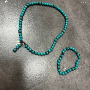 Turkost pärlset med halsband och armband - Snyggt set med turkost pärlhalsband och matchande armband. Båda smyckena har små silverfärgade detaljer och ett charmigt hänge. Perfekt för att ge en färgklick till din outfit!