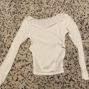 Vit topp - Jättemjuk vit topp med v ringning, samt slits på sidorna som går upp magen. Jättesnygg och oanvänd topp med prislapp. 🤍