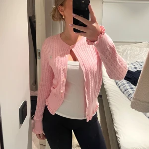 Ralph Lauren kofta  - Säljer en superfin rosa stickad kofta från Ralph Lauren. Den har ett klassiskt kabelstickat mönster. Koftan är långärmad och har en liten grön logga på bröstet. Perfekt för både vår och höst! XL i barnstolen men sitter som XS - S. Skicka prisförslag!