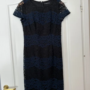 Svart spetsklänning från Esprit - Snygg svart spetsklänning från Esprit med korta ärmar och ett elegant mönster. Perfekt för festliga tillfällen. Klänningen har en dragkedja i ryggen för enkel påklädning.