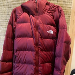 Nypris 2699kr The North Face varm vinterjacka, XL - En vinröd dunjacka med huva från The North Face. Jackan har en dragkedja framtill och två fickor på sidorna. Jackan är sparsamt använd, inga fläckar. För herr.