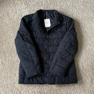 John Henric Jacka - En marinblå höst/vinterjacka från John Henric. Aldrig använd så i nyskick. Däremot är en knapp längst ner påsydd hos skräddare. Hör av dig vid frågor eller funderingar!