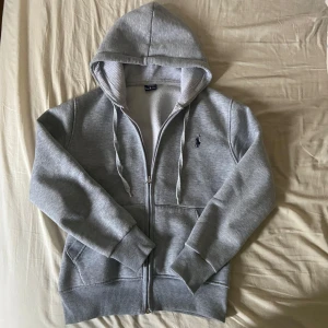 Ralph Lauren zip hoodie - Ralph Lauren zip hoodie i färgen grå. Storlek M men sitter som mindre. Gamla modellen så märket är lite större än vanligt. Inget fel med den alls och priset går säkert att diskutera. Dm för fler bilder.