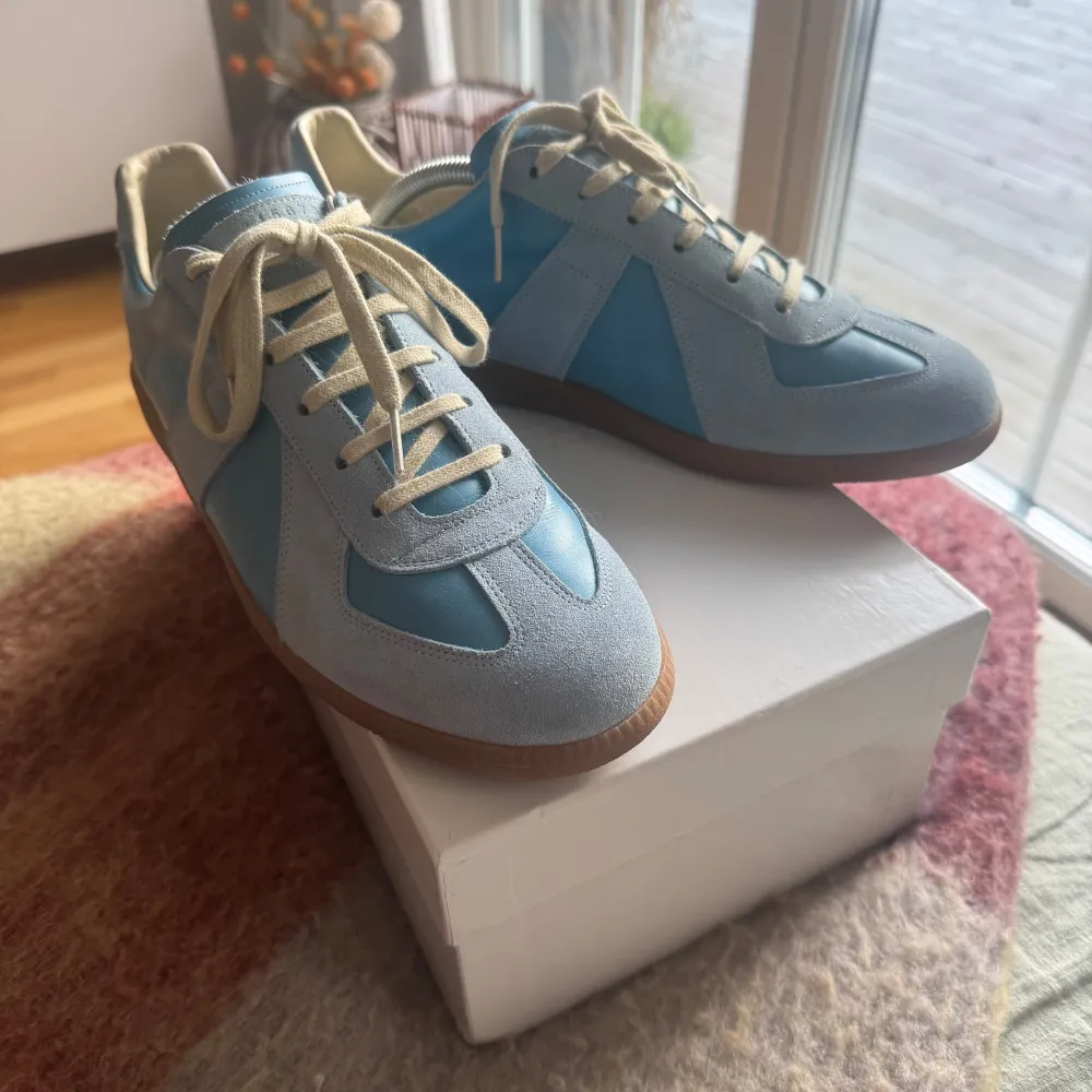 Säljer ett par maison margiela sneakers i näst intill nyskick. Skorna är i storlek 43.. Skor.