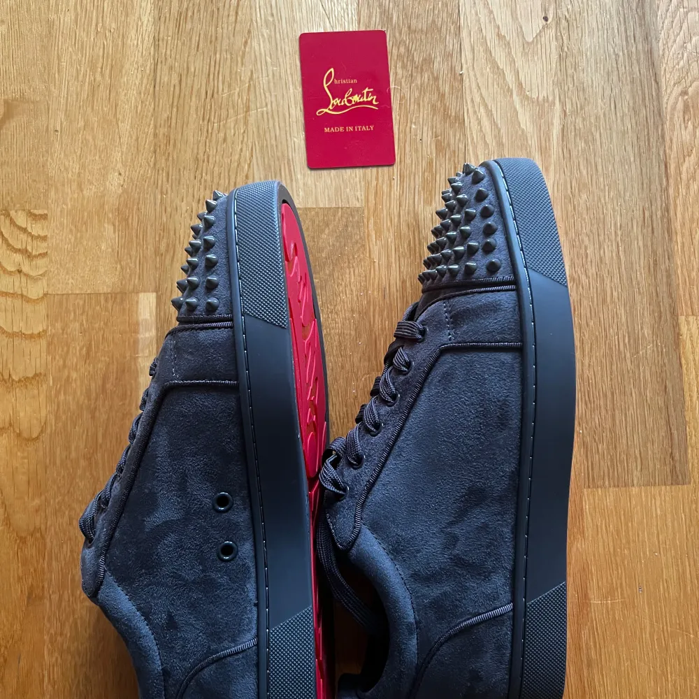 Christian Louboutin sneakers, helt nya i mörkgrå mocka med ikonisk röd sula och spikar på hälen. Perfekta för både fest och vardag. Storlek: (43). Oanvända och i toppskick! Pris: (2000). Kontakta för mer info pris kan diskuteras!. Skor.