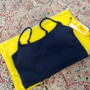 Sport bh - Mörkblå sport bh med öppen rygg storlek M, helt ny, aldrig använd och taggen kvar.   För liten för mig och gick inte att returnera därför säljer jag den. 