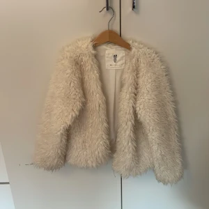 Jacka  - En varm, mysig och lurvig jacka. 