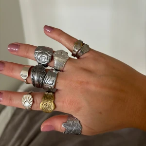 Unika silverringar i olika designer - Säljer flera unika silverringar i olika designer. Varje ring har sin egen stil, från blommönster till mer abstrakta former. Perfekt för att mixa och matcha till olika outfits och tillfällen. De är i nyskick och redo att bäras