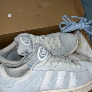 Adidas Campus 00 - Säljer dessa jättefina ljusblåa campus 00or som jag köpte precis innan sommaren i jdsports för 1300. Har endast använt de ett fåtal gånger under sommaren och de har inga deffekter. Inga större tecken på användning. Pris går att diskuteras