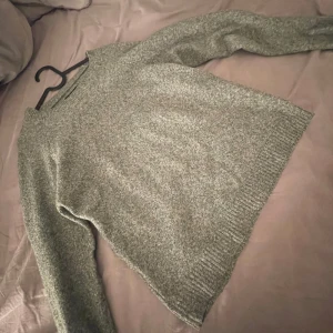 Grå stickad tröja från Vero Moda - Säljer en supermysig grå stickad tröja från Vero Moda. Perfekt för kyliga dagar med sin mjuka och bekväma passform. Tröjan har långa ärmar och ribbade kanter som ger en snygg finish. Passar perfekt till både jeans och kjol!