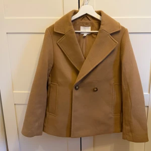 Kort kappa - Hej, säljer denna super snygga kappan i storlek S. Ganska tjock och har typ ett dubbellager,den är i en chestnutig färg som passar så bra till hösten. Använd fåtal gånger så den är som ny. 