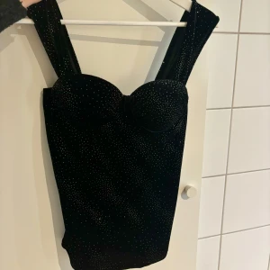 Glittrig svart topp - Supersnygg glittrig svart topp🩶Stretchigt material, så passar lite vem som men kanske xs/s/m. Kuporna skulle jag säga passar allt från B-D💕