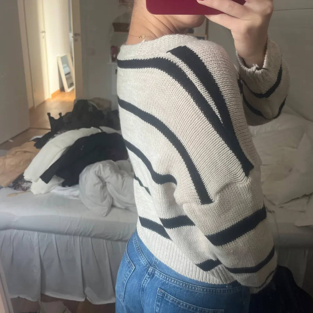 Säljer en supermysig randig kofta i beige och svart. Den har en v-ringad design och stora, snygga knappar framtill. Perfekt för en avslappnad look och passar bra till jeans. Koftan är i ett stickat material som känns både mjukt och bekvämt. Perfekt för höst och vår!. Tröjor & Koftor.