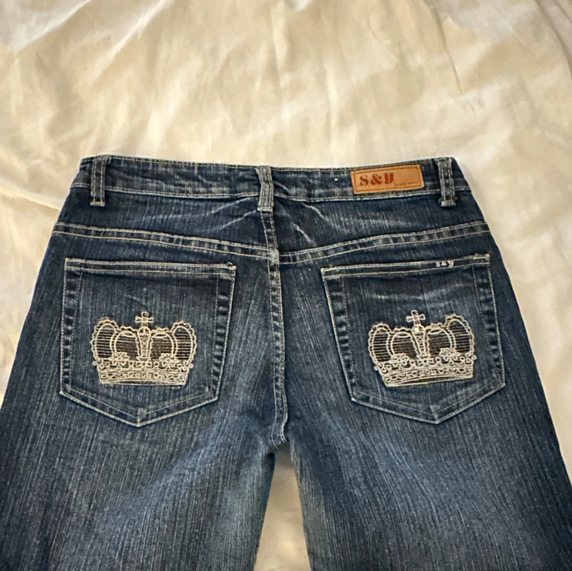 Blå jeans med broderade kronor