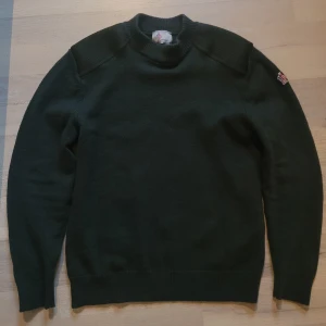 Mörkgrön tröja från Moncler - Säljer en snygg mörkgrön tröja från Moncler. Den är i mycket bra skick och perfekt för höst och vinter. Tröjan har långa ärmar och en broderad logga på ärmen. Den är gjord i ett mjukt och bekvämt material, perfekt för kyliga dagar.