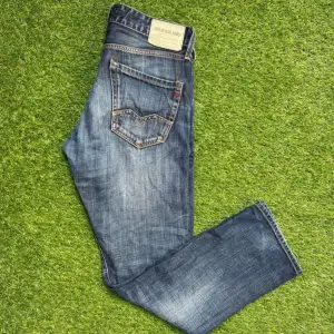 Säljer ett par snygga blå Replay jeans i midwaist-modell. De har en klassisk femficksdesign med slitna detaljer för en cool look. Perfekta för både vardag och fest! 🕺